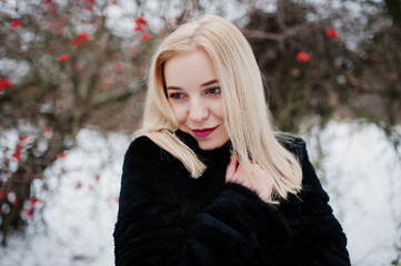 Blonde girl posed at winter snowy day.