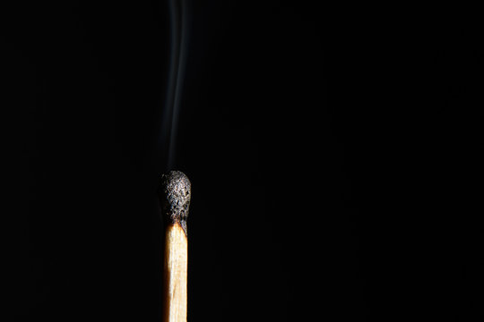 Match with the burned head and heavily steaming up on a black background closeup