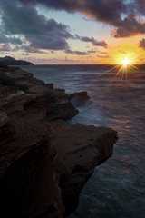 Sunrise illuminates the Makawehi lithified cliffs on Kauai's southern coast.