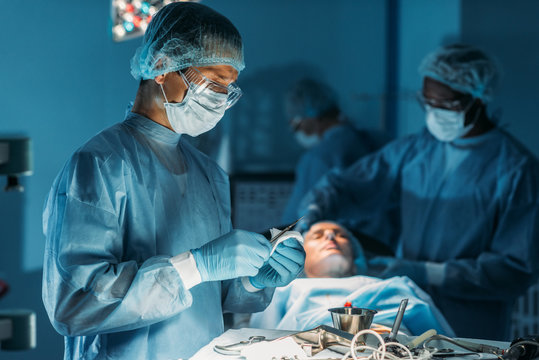 surgeon cleaning scalpel in surgery room