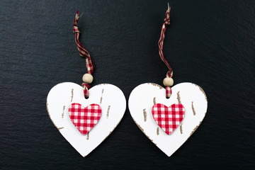 Two hearts of wood on black slate