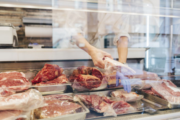 Butcher arranging meat on display in Sweden