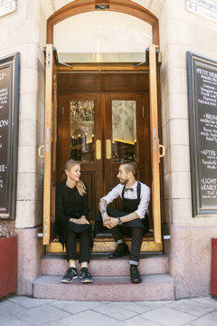Waiters on front door step of bakery in Sweden