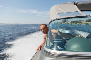 Captain driving a boat on a river