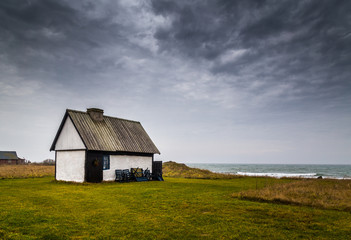 White stone house on the coast on a cloudy day