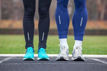 Fototapeta premium Front cropped view of two runners in running shoes.
