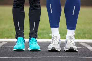 Fototapeta premium Front cropped view of two runners in running shoes.