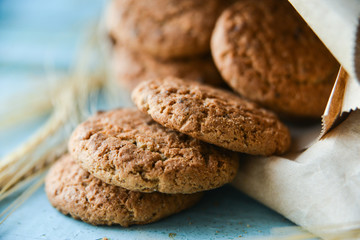 fresh oatmeal cookies in a bag made of paper on wooden background
