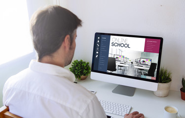 man browsing online school on computer