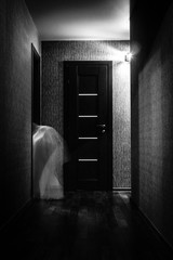 Ghost walks through the old house at night. home bogle in a white. Ghost in the dark room