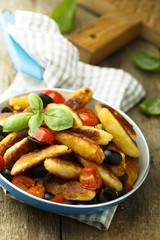 Fried potato fingers with olives, tomato and basil