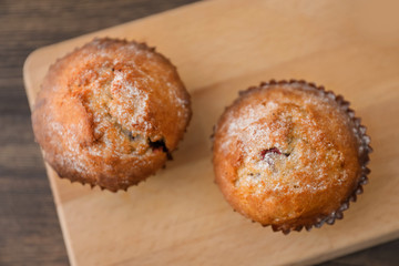 Freshly baked cupcakes on wooden board