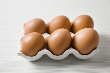 Holder with chicken eggs on light table