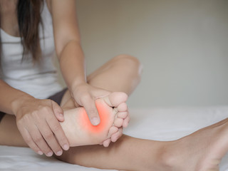 Young woman feeling pain in her foot at home. Healthcare and medical concept.