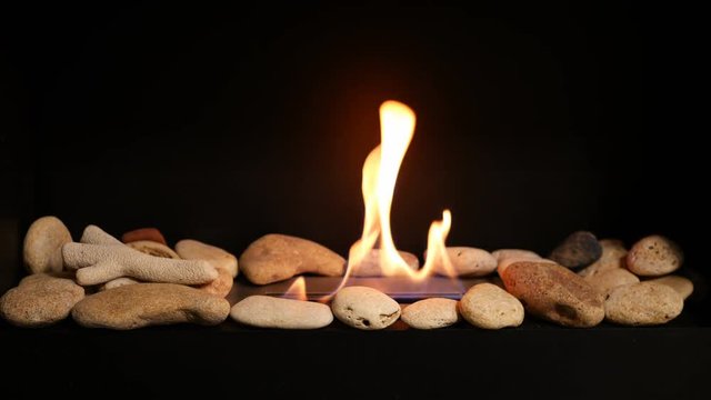 Modern interior bio fireplace with close up flame shooting. Fire flame flames of roaring gas burning outdoors at night
