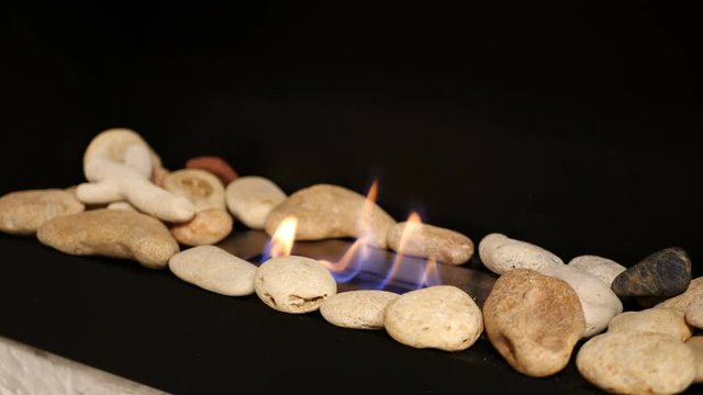 Modern interior bio fireplace with close up flame shooting. Fire flame flames of roaring gas burning outdoors at night