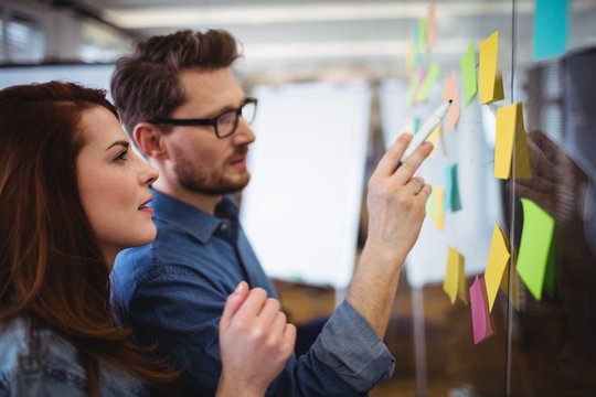 Creative Business People Looking At Sticking Notes