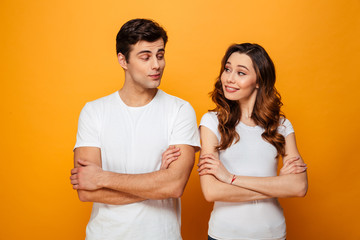 Portrait of a smiling young couple standing with arms folded