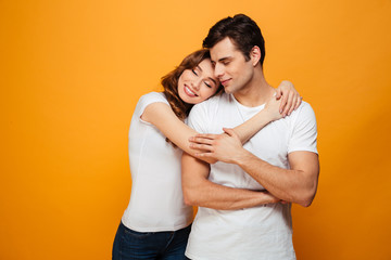 Image of Young lovely couple posing together and hugging