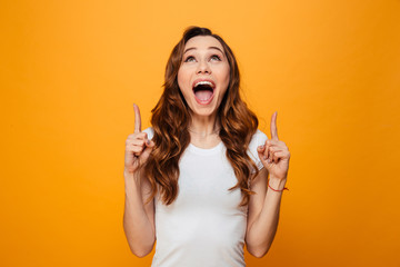 Happy screaming brunette woman in t-shirt pointing and looking up