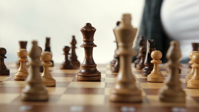 Woman moving chess figure with team behind - strategy, management or leadership concept