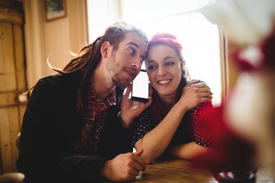 Hipster couple listening to music on smartphone