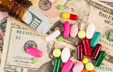 Top view of various pills and dollar banknotes