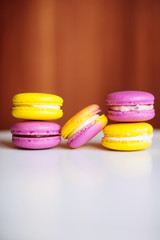 Vibrant colorful macarons on white wooden table. Text space