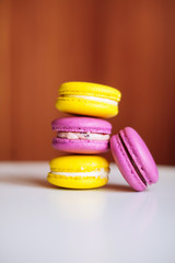 Vibrant colorful macarons on white wooden table. Text space