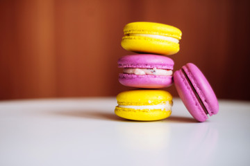 Vibrant colorful macarons on white wooden table. Text space
