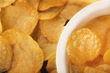 Pile of crispy potato chips lying  on an old concrete table in kitchen. Concept of fast food background. Free place for text, top view.