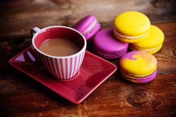 colored macaroons and a Cup of coffee on a wooden table, color macaroons ultraviolet