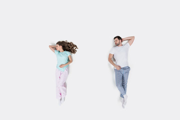 top view of couple in pajamas lying isolated on white