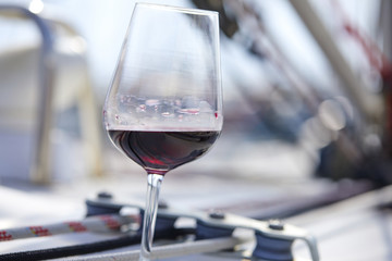 a glass of red wine on the deck of the yacht