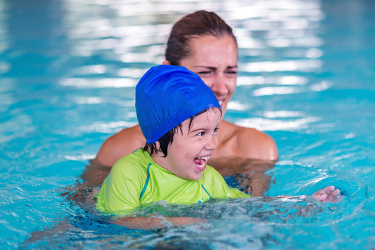 Little boy on swimming class with mother