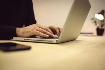 Close-up of man hands while using laptop.