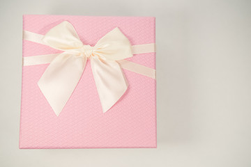 Pink gift box with tie on white background. Minimal concept.