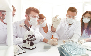 medical doctors are working with test tubes and microscope at the lab