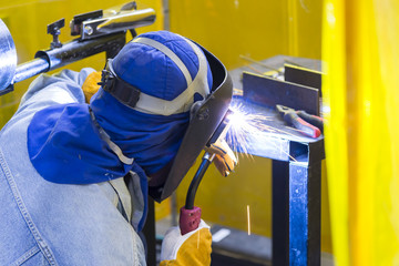 The worker welding the structure by using the electric welding machine.