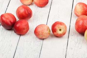 Ripe red peaches on the white wooden table