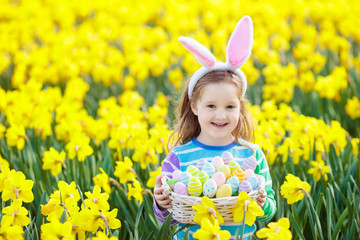 Child with bunny ears on Easter egg hunt