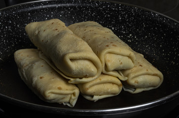 Pancakes stuffed in a frying pan on an induction cooker