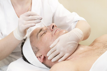 Fototapeta na wymiar Man in the mask cosmetic procedure in spa salon. 