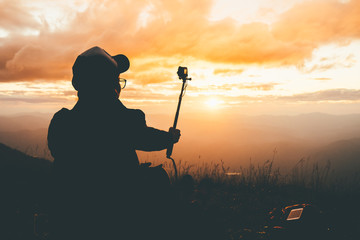 Silhouette girl selfie alone on mountain sunset time.