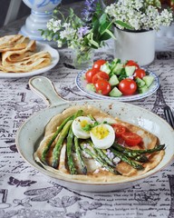 Breakfast of pancakes baked with asparagus with boiled egg and cream cheese