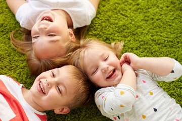 happy little kids lying on floor or carpet