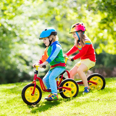 Kids ride balance bike in park