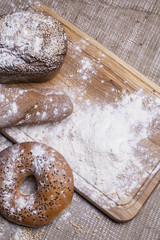 picture of high quality food with a picture of delicious fresh rustic bread buns on a background of sackcloth on a cutting wooden board in the style of Provence
