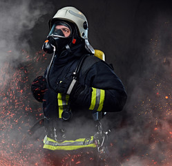 A firefighter dressed in a uniform in a studio.