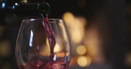 In winter, before the fireplace, is poured, tasted red wine in a glass. Concept of: relax, restaurant, wine, somelier.